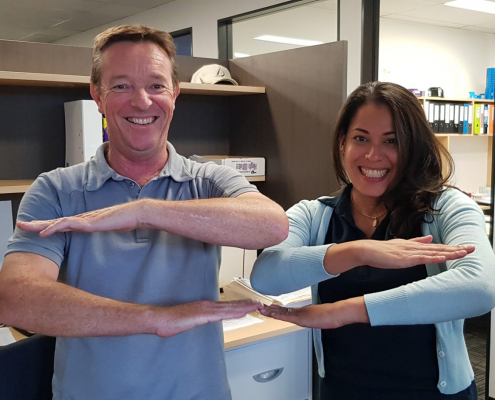 Alder team members making an equal sign with their arms